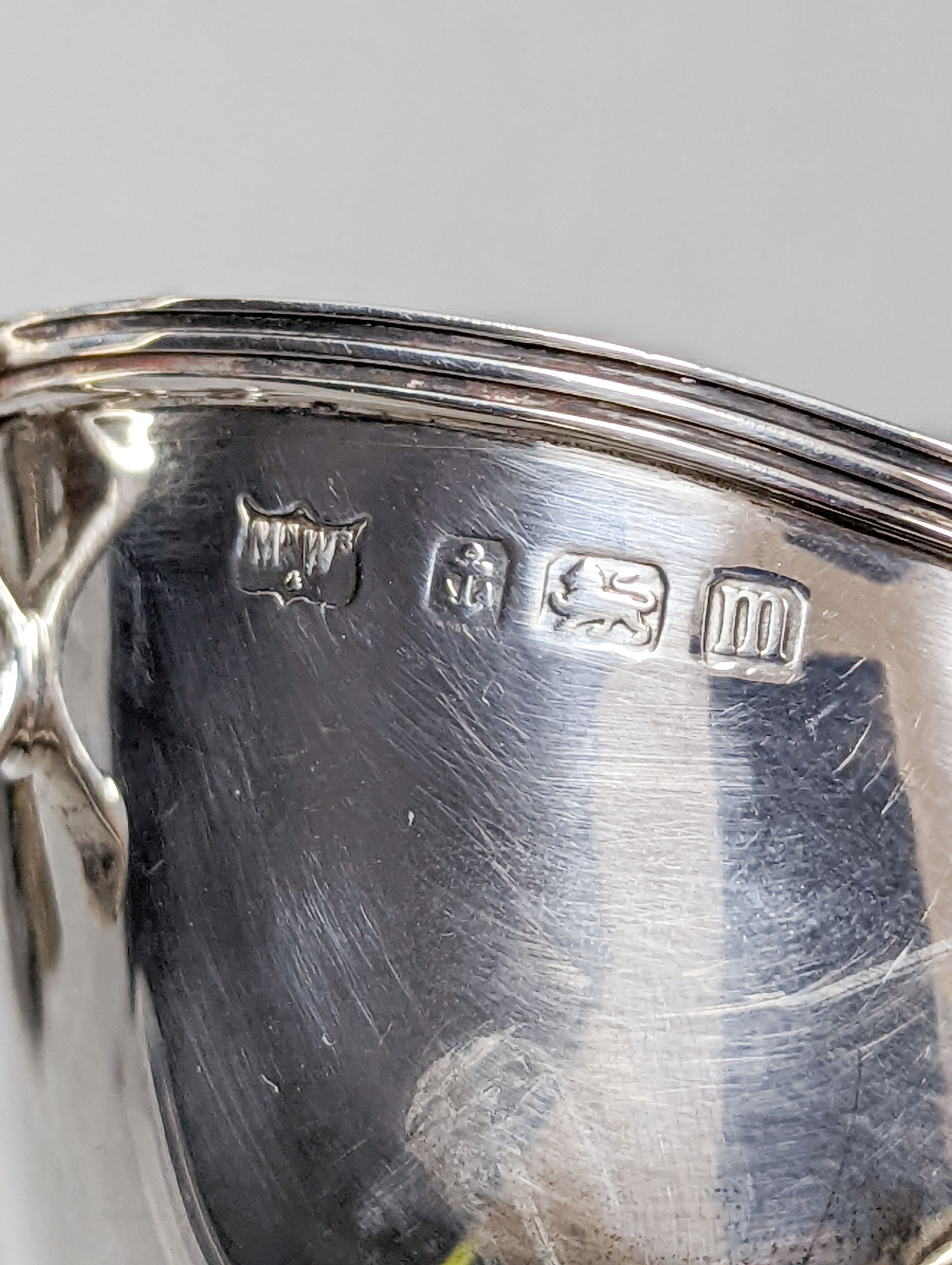 A George V silver sauceboat by Mappin & Webb, Birmingham, 1911, an Edwardian silver tri-handled bowl, a late Victorian repousse silver box and a George V silver sifter spoon, 11oz.